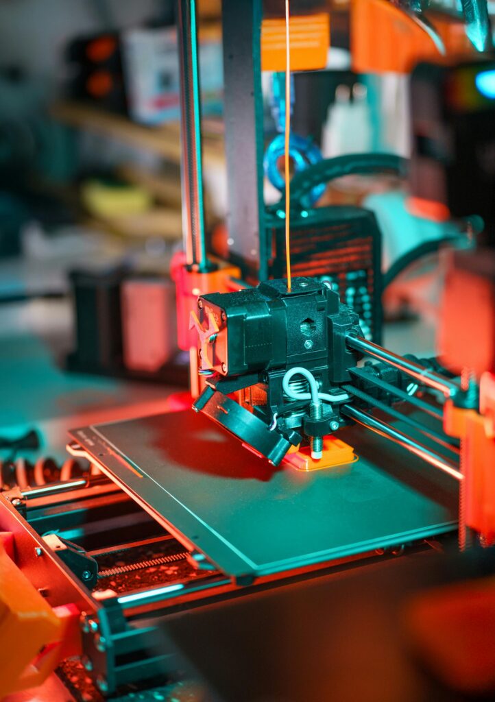 Close-up of a 3D printer crafting a prototype model in a workshop setting.