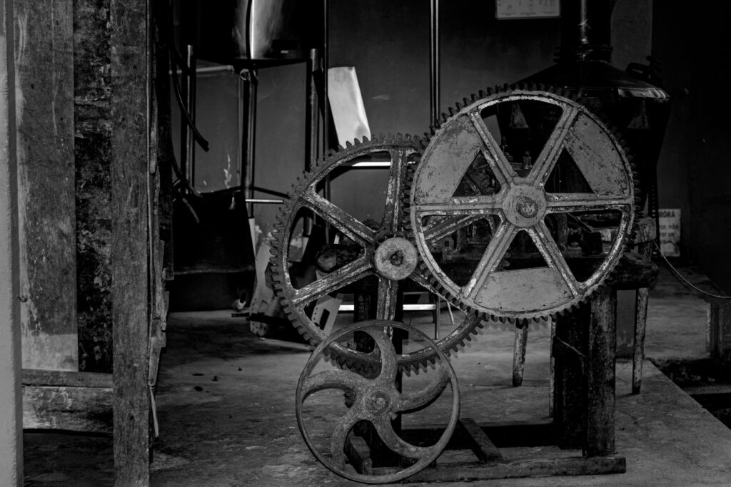 Black and white photo capturing rustic gears in an industrial setting.