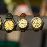 Home Assorted vintage watches with leather straps on a display rack.