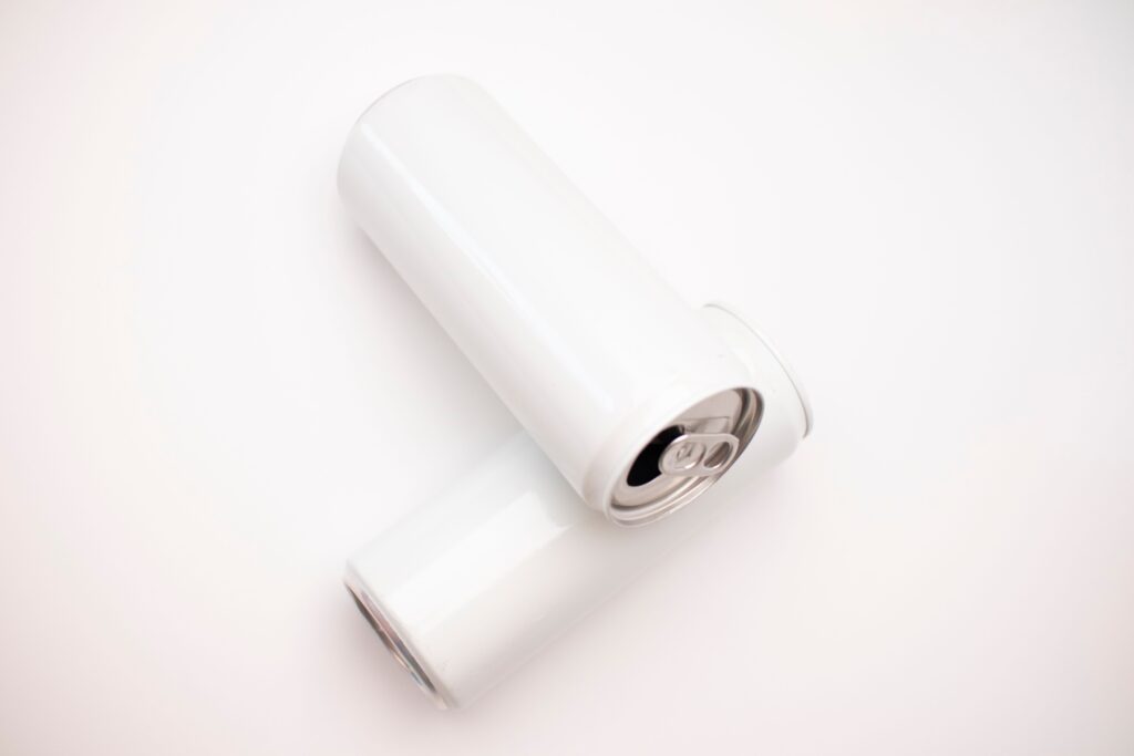 Simple and clean mockup featuring two plain white cans on a white surface with ample copyspace.